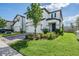 Well-manicured front yard with green lawn, attractive landscaping, and a two-story home featuring a two car garage at 7517 Notched Pine Bnd, Wesley Chapel, FL 33545