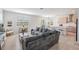 Open concept living space with a gray sectional sofa, tile floors, and views of the kitchen at 7517 Notched Pine Bnd, Wesley Chapel, FL 33545