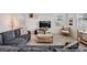Comfortable living room with a large sectional sofa, tile flooring, and plenty of natural light at 7517 Notched Pine Bnd, Wesley Chapel, FL 33545