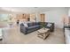 Open floor plan with a spacious gray sectional sofa connecting living and kitchen areas at 7517 Notched Pine Bnd, Wesley Chapel, FL 33545