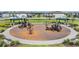 Community playground featuring multiple slides, swings, covered picnic area and well maintained mulch and landscaping at 7517 Notched Pine Bnd, Wesley Chapel, FL 33545