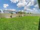Wide shot of a large backyard with new sod and a tall privacy fence at 7700 Bronze Oak Dr, Wesley Chapel, FL 33545
