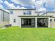 Large backyard featuring an enclosed patio with a dining area and green grass at 7700 Bronze Oak Dr, Wesley Chapel, FL 33545