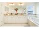 Bright bathroom with double vanity, large mirror, soaking tub, and glass shower at 7700 Bronze Oak Dr, Wesley Chapel, FL 33545