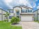 Charming two-story home boasting stone accents, blue shutters, and lush green lawn at 7700 Bronze Oak Dr, Wesley Chapel, FL 33545