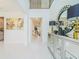 Bright foyer featuring white tile flooring, a decorative mirror, and ample natural light at 7700 Bronze Oak Dr, Wesley Chapel, FL 33545