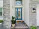 Elegant front entrance with a decorative blue door and stone detailing at 7700 Bronze Oak Dr, Wesley Chapel, FL 33545