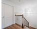 Hallway with wood floors leading to a stairway and featuring a modern chandelier at 7700 Bronze Oak Dr, Wesley Chapel, FL 33545