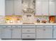 Modern kitchen features mosaic backsplash, stainless steel hood, and sleek countertops at 7700 Bronze Oak Dr, Wesley Chapel, FL 33545