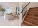 Inviting living room with stylish decor, elegant staircase, and abundant natural light at 7700 Bronze Oak Dr, Wesley Chapel, FL 33545