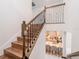 Elegant staircase with wood treads and black iron railing overlooking the kitchen at 7700 Bronze Oak Dr, Wesley Chapel, FL 33545