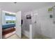A well-lit bathroom features a bathtub shower combination with glass surround and cityscape views at 777 N Ashley Dr # 1903, Tampa, FL 33602