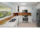 Well-lit kitchen features white cabinetry, stainless steel appliances, and a stylish backsplash for a modern look at 791 66Th S Ave, St Petersburg, FL 33705