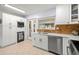 Bright kitchen with stainless steel dishwasher, quartz countertops, and white cabinets for ample storage space at 791 66Th S Ave, St Petersburg, FL 33705