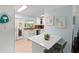 Efficient kitchen with white cabinets, stainless steel appliances, and a breakfast bar overlooking the living area at 791 66Th S Ave, St Petersburg, FL 33705
