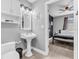 This gray bathroom has decorative wall art, a vessel sink, and a view into the neutral toned bedroom at 8108 E 19Th Ave, Tampa, FL 33619