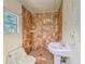 Tiled bathroom features a toilet, sink, and walk-in shower with window and natural light at 8108 E 19Th Ave, Tampa, FL 33619