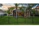 Beautiful backyard featuring a lush lawn, mature trees, a screened-in patio, and a sleek black fence at 8358 Dunham Station Dr, Tampa, FL 33647
