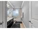 Well-lit bathroom with a sleek vanity, a shower-tub combo, and neutral-colored tile flooring at 8358 Dunham Station Dr, Tampa, FL 33647