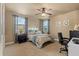 Bright bedroom with a ceiling fan, comfortable bed, and neutral colors with an adjacent office desk at 8358 Dunham Station Dr, Tampa, FL 33647