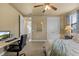 Comfortable bedroom with carpet, ceiling fan, desk and chair, a view from the window, and access to the bathroom at 8358 Dunham Station Dr, Tampa, FL 33647