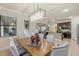 Dining room features a contemporary chandelier, a wooden table with seating, and access to kitchen and living spaces at 8358 Dunham Station Dr, Tampa, FL 33647
