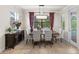 Dining area featuring a wooden table with seating, stylish decor, and access to outdoor pool area through glass doors at 8358 Dunham Station Dr, Tampa, FL 33647
