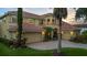 Grand two-story home showcasing a terracotta roof, manicured landscaping, three-car garage, and brick paver driveway at 8358 Dunham Station Dr, Tampa, FL 33647