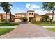 Stunning Mediterranean home with a tile roof, brick driveway, and lush landscaping at 8358 Dunham Station Dr, Tampa, FL 33647