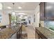 Open kitchen featuring a granite island, stainless appliances, dark wood cabinets, and views of the living area at 8358 Dunham Station Dr, Tampa, FL 33647