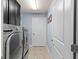 Well-lit laundry room features a modern washer and dryer set, ample cabinet space, and stylish tile flooring at 8358 Dunham Station Dr, Tampa, FL 33647