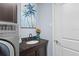 Beautiful laundry room features granite countertops, a modern sink, and elegant decor with palm tree artwork at 8358 Dunham Station Dr, Tampa, FL 33647