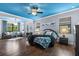 Spacious main bedroom with hardwood floors, a blue ceiling, and a seating area at 8358 Dunham Station Dr, Tampa, FL 33647