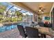 Beautiful outdoor pool area with a screened-in enclosure, patio seating, and lush greenery in the background at 8358 Dunham Station Dr, Tampa, FL 33647
