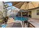 A shaded patio with outdoor lounge furniture overlooks the pool and spa within a screened enclosure at 8358 Dunham Station Dr, Tampa, FL 33647