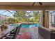 Beautiful screened-in pool area with a hot tub, palm trees, an outdoor seating area, and plenty of sunshine at 8358 Dunham Station Dr, Tampa, FL 33647
