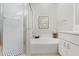 Bright bathroom with a combined shower and tub, white tiled walls, and black and white patterned shower floor at 8624 Snowy Owl Way, Tampa, FL 33647
