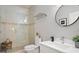 Neutral bathroom boasts glass shower, tile floor, and white vanity at 8624 Snowy Owl Way, Tampa, FL 33647