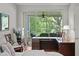 Bedroom featuring a work-from-home setup, including a desk, chair, and view of the screened-in porch at 8624 Snowy Owl Way, Tampa, FL 33647