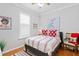 Comfortable bedroom features a queen bed with heart-themed pillows and bedding, natural light, and hardwood floors at 8624 Snowy Owl Way, Tampa, FL 33647