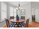 Dining room featuring a round wooden table, patterned chairs, and bright light from white shutters at 8624 Snowy Owl Way, Tampa, FL 33647
