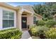 Inviting front entrance with a black door, decorative wreath, and lush landscaping at 8624 Snowy Owl Way, Tampa, FL 33647