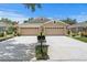Charming home featuring a double garage, well-manicured lawn, and inviting curb appeal at 8624 Snowy Owl Way, Tampa, FL 33647