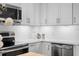 Modern kitchen featuring white cabinets, subway tile backsplash, stainless steel appliances, and solid surface countertops at 8624 Snowy Owl Way, Tampa, FL 33647