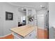 Open kitchen with island featuring a wood countertop, white cabinets, and wood floors at 8624 Snowy Owl Way, Tampa, FL 33647