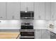 Bright kitchen with stainless steel appliances, white cabinets, and subway tile backsplash at 8624 Snowy Owl Way, Tampa, FL 33647
