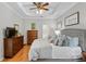 Spacious bedroom featuring a tray ceiling, dresser, king bed with many pillows, and ensuite bath at 8624 Snowy Owl Way, Tampa, FL 33647