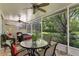 Screened-in patio with ceiling fans, outdoor dining set, and view of the garden at 8624 Snowy Owl Way, Tampa, FL 33647