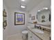 Well-lit bathroom with a granite countertop vanity, round mirror and neutral paint at 1 Beach Se Dr # 811, St Petersburg, FL 33701