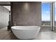 Bright bathroom featuring a standalone tub, floor-to-ceiling tiles, and a large window with city views at 100 1St N Ave # 3905, St Petersburg, FL 33701